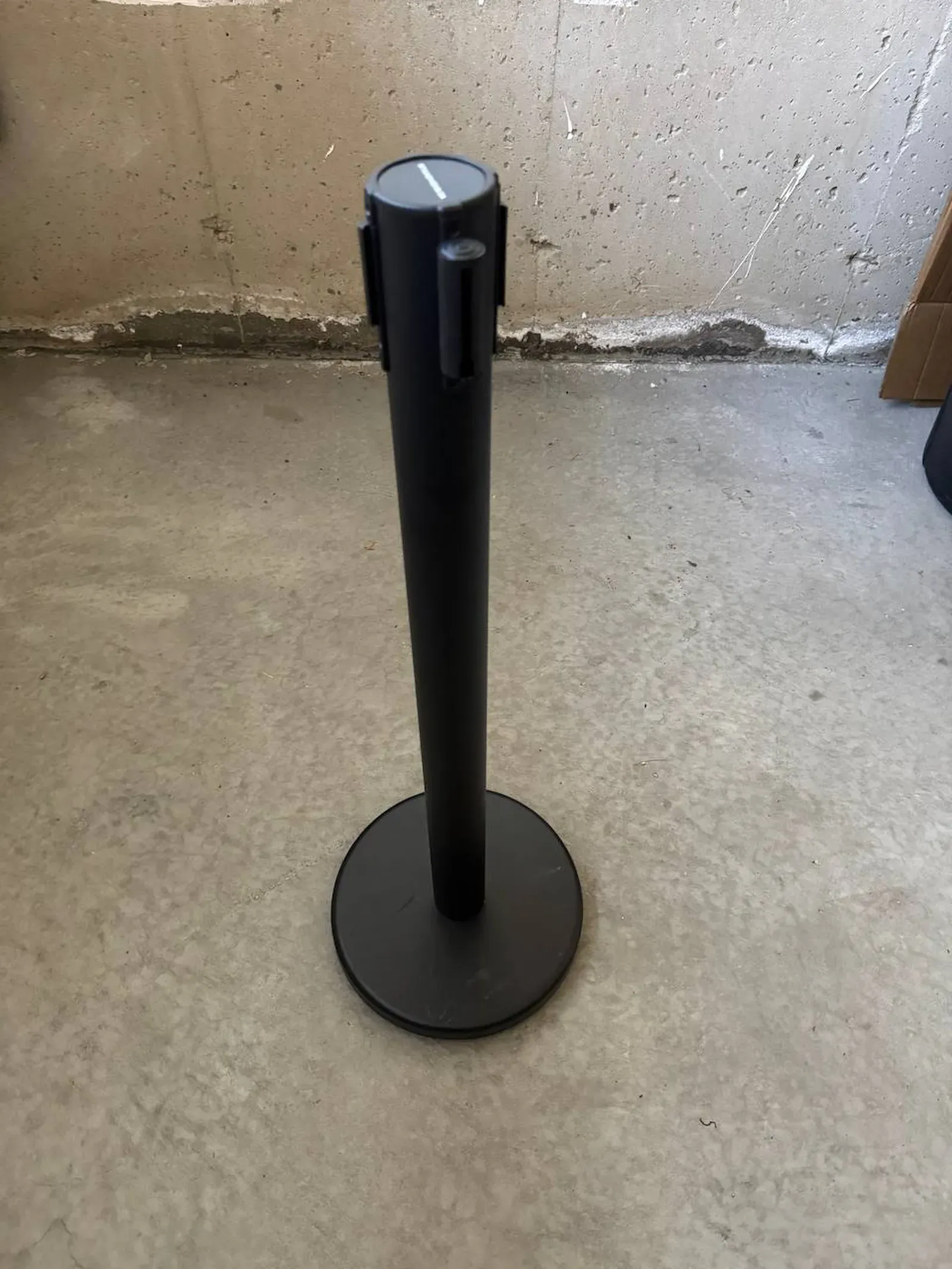 A single black belt stanchion post with its belt extended